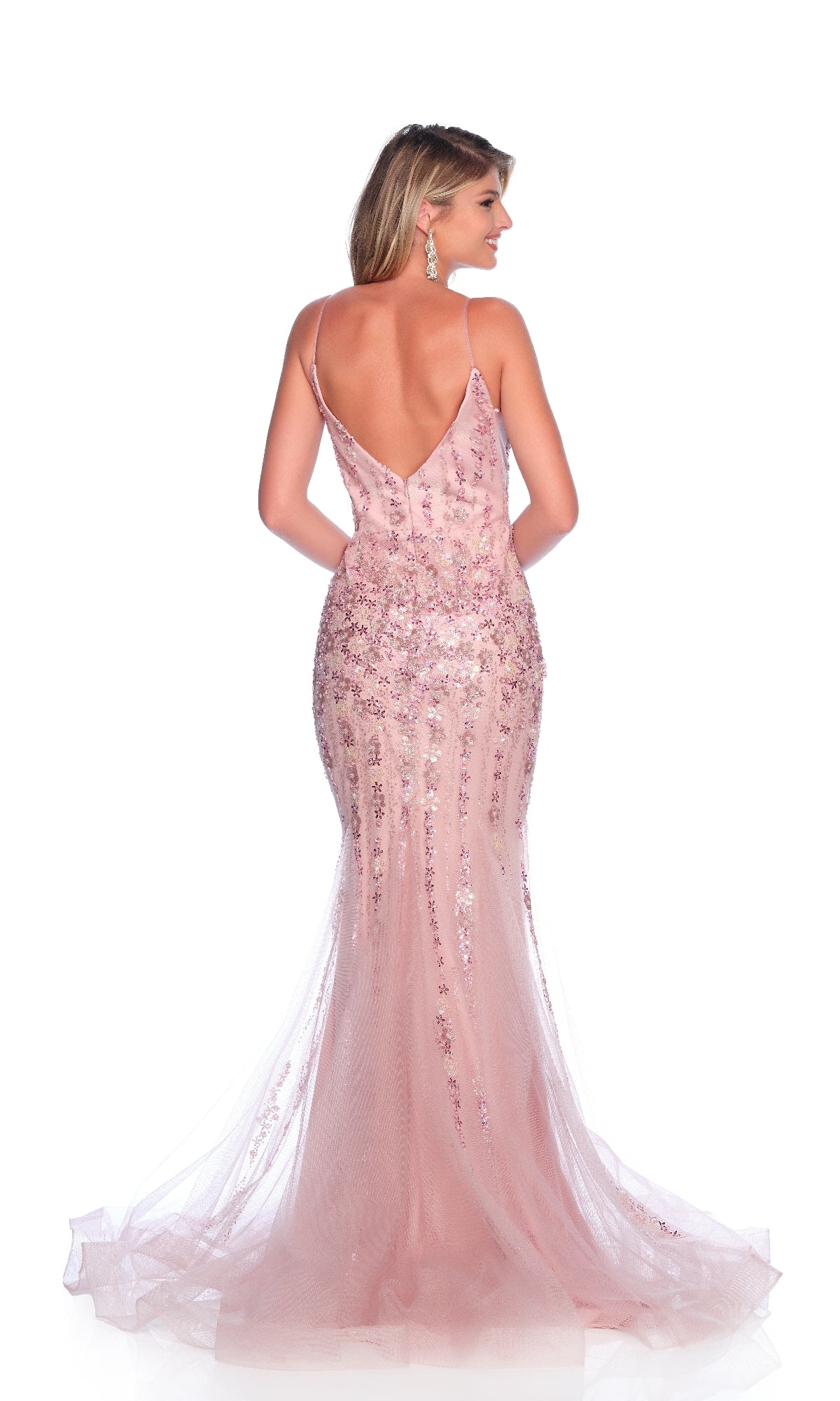 A woman faces away, wearing the Dave and Johnny 12004 long prom dress—a light pink mermaid gown with sequins and a flared train, radiating designer elegance.